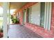 Inviting front porch with stylish tile, brick accents and views of the surrounding landscape at 5801 Poinciana Ave, Lakeland, FL 33809