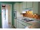 Well-lit kitchen with white cabinets, copper tile backsplash and modern appliances at 5801 Poinciana Ave, Lakeland, FL 33809