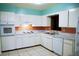 Charming kitchen with white appliances, tiled floor and ample countertop space at 5801 Poinciana Ave, Lakeland, FL 33809