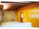 Open living room showcasing wood paneled walls, beamed ceilings and decorative stone accent wall at 5801 Poinciana Ave, Lakeland, FL 33809