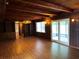 Spacious living room featuring wood paneled walls, built in shelves, beamed ceiling and lanai access at 5801 Poinciana Ave, Lakeland, FL 33809