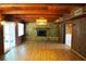 Living room features wood paneled walls, beamed ceiling, stone fireplace, and access to a lanai at 5801 Poinciana Ave, Lakeland, FL 33809