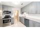 Modern kitchen featuring sleek gray cabinets, granite countertops, and stainless steel appliances at 760 Formosa Ave, Bartow, FL 33830
