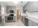 Well-lit kitchen featuring grey cabinets, stainless steel appliances, and granite countertops at 760 Formosa Ave, Bartow, FL 33830