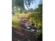 Beautiful backyard garden with stone path, bird bath, garden lights and lush foliage for a serene outdoor space at 925 Fenton Ln # 11, Lakeland, FL 33809