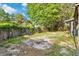 Shot of a backyard with fence and some grass, under a blue sky with some clouds and trees at 1586 Fergason Ave, Deltona, FL 32725