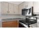 Kitchen close-up with cabinets, granite counters and modern stainless steel appliances at 1586 Fergason Ave, Deltona, FL 32725