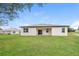 Spacious backyard with lush green grass and a covered patio, perfect for outdoor activities at 421 Arkansas Ct, Poinciana, FL 34759