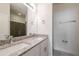 Modern bathroom featuring a double sink vanity with granite countertop and a glass-enclosed shower at 421 Arkansas Ct, Poinciana, FL 34759