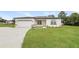 Inviting single-story home features a lush lawn, paved driveway, and attached two car garage at 421 Arkansas Ct, Poinciana, FL 34759