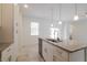 Close up on kitchen island featuring granite countertops, stainless steel appliances, and white cabinetry at 421 Arkansas Ct, Poinciana, FL 34759