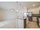Bright kitchen featuring white cabinets, stainless steel appliances, and granite countertops overlooking living area at 421 Arkansas Ct, Poinciana, FL 34759