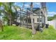 The backyard is surrounded by a screened lanai, patio, pool and lush tropical landscaping at 3221 Dark Sky Dr, Harmony, FL 34773