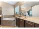 A spacious bathroom with a large tub, dark wood vanity, and large mirror at 3221 Dark Sky Dr, Harmony, FL 34773