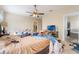 Bedroom with a ceiling fan and cluttered with various items on the bed and floor at 3221 Dark Sky Dr, Harmony, FL 34773