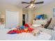 Bedroom featuring a ceiling fan, window, and furniture; shows some clutter at 3221 Dark Sky Dr, Harmony, FL 34773