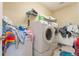 Laundry room with front loading washer and dryer and cluttered shelving at 3221 Dark Sky Dr, Harmony, FL 34773
