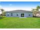 Home exterior displaying a well-manicured lawn and a paved patio at 13 Haddock Way, Poinciana, FL 34759