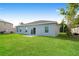 Home exterior showing manicured lawn, sliding glass door, and ample space at 13 Haddock Way, Poinciana, FL 34759