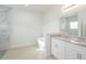 Bright bathroom with a modern tub, granite countertops, double sinks and large mirror at 13 Haddock Way, Poinciana, FL 34759