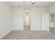 Bright, carpeted bedroom with a ceiling fan and entrance to a hallway at 13 Haddock Way, Poinciana, FL 34759
