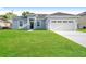 Charming single-story home with a well-manicured lawn and a two-car garage at 13 Haddock Way, Poinciana, FL 34759