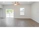 Inviting living space featuring wood floors, a ceiling fan and a sliding glass door to the backyard at 13 Haddock Way, Poinciana, FL 34759