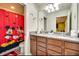 Bright bathroom with a double sink vanity, granite countertops, and decorative Disney themed shower curtain at 8882 Geneve Ct, Kissimmee, FL 34747