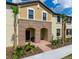 Charming multi-level townhome features landscaped front yard and covered entryway at 8882 Geneve Ct, Kissimmee, FL 34747