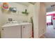 Well-equipped laundry room features a washer, dryer, wire shelving, and ironing board at 8882 Geneve Ct, Kissimmee, FL 34747
