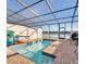 Relaxing screened pool area boasts blue tiled pool, brick pool deck, and lake views at 8882 Geneve Ct, Kissimmee, FL 34747