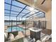 Relaxing screened pool area boasts brick pool deck, blue tiled pool, and outdoor fire table at 8882 Geneve Ct, Kissimmee, FL 34747