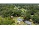 Aerial view of home showcasing the property's boundaries, lawn, and surrounding green, mature trees at 1143 Ne 23Rd St, Ocala, FL 34470
