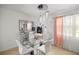 Modern dining room with stylish chandelier and a glass dining table with white chairs at 1143 Ne 23Rd St, Ocala, FL 34470