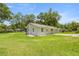 Single-story home with spacious green lawn, patio and mature trees at 1143 Ne 23Rd St, Ocala, FL 34470