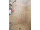 Shower with tan tile, mosaic border, shower head, and tiled floor at 1143 Ne 23Rd St, Ocala, FL 34470