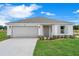 Charming one-story home featuring a neutral color palette, well-manicured landscaping, and an attached two-car garage at 18 Haddock Way, Poinciana, FL 34759