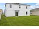 The back of the house has a well-maintained lawn, a sliding glass door, and is surrounded by similar houses at 2222 Oklahoma Dr, Sumterville, FL 33585