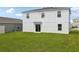 A back exterior view showing a well-manicured green lawn and a sliding glass door at 2222 Oklahoma Dr, Sumterville, FL 33585