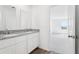 Bright bathroom showcasing double vanity with granite countertop and wood-look flooring at 2222 Oklahoma Dr, Sumterville, FL 33585
