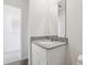 Bathroom vanity features gray granite countertops, white cabinets, and a modern rectangular mirror at 2222 Oklahoma Dr, Sumterville, FL 33585