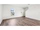 Bright, airy living space with wood-look flooring, featuring a view of the neighborhood through a window at 2222 Oklahoma Dr, Sumterville, FL 33585