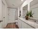 Bright bathroom featuring a double vanity with granite countertops, a walk-in shower, and modern fixtures at 2383 Oklahoma Dr, Sumterville, FL 33585