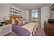Bright bedroom featuring stylish decor, a cozy bed, and a large window offering scenic views at 2383 Oklahoma Dr, Sumterville, FL 33585
