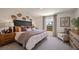 Cozy bedroom with neutral tones, a decorative headboard, plush bedding, and a comfortable chair at 2383 Oklahoma Dr, Sumterville, FL 33585