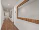 Hallway featuring wood-look flooring and a large decorative mirror, enhancing the home's interior design at 2383 Oklahoma Dr, Sumterville, FL 33585
