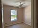 Bedroom features a ceiling fan and large, window with security bars at 1152 Mccormick Dr, Deltona, FL 32725