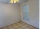 Cozy bedroom featuring a window with blinds, neutral walls, and tiled flooring at 1152 Mccormick Dr, Deltona, FL 32725