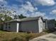 A single-Gathering home with light-grey colored stucco siding with a grassy yard at 1152 Mccormick Dr, Deltona, FL 32725