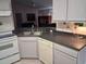 Charming kitchen features a stainless steel sink, dark countertops, and classic white cabinetry at 1152 Mccormick Dr, Deltona, FL 32725